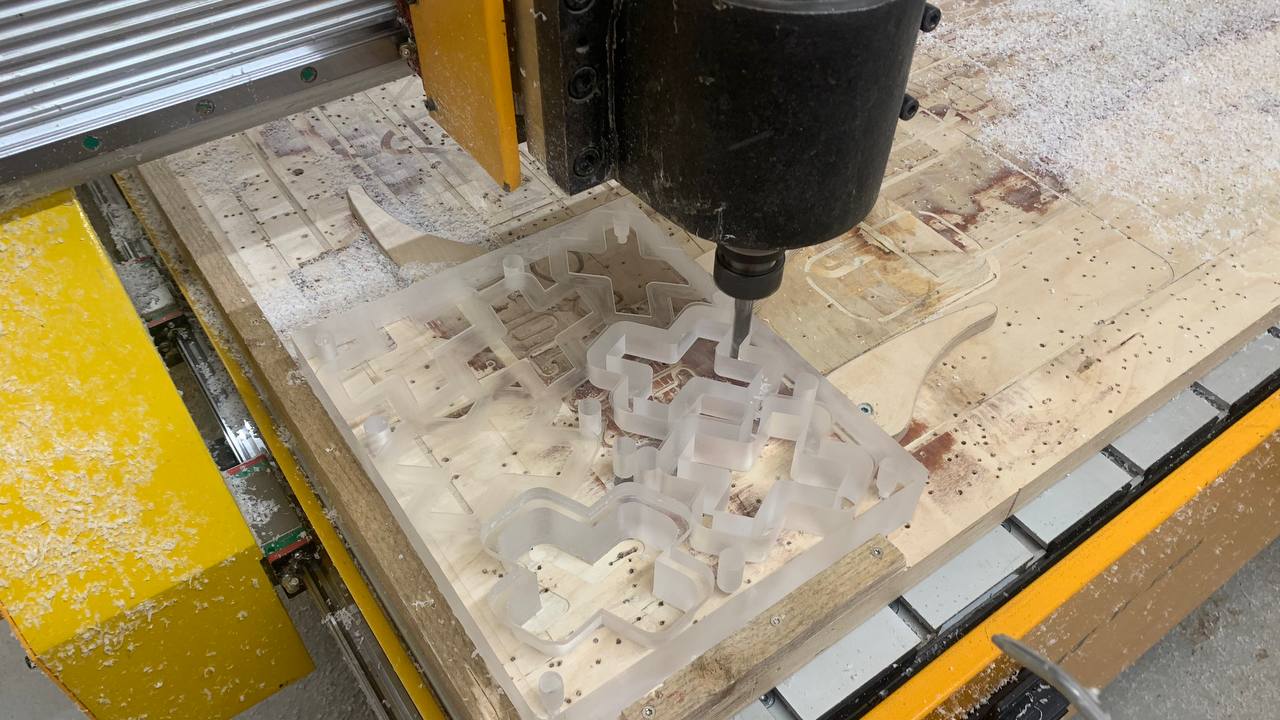CNC-kone jyrsimässä akryylilevyä Creative Cruen brändisymboleiksi.