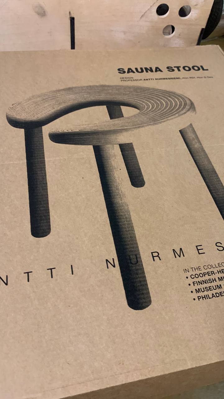 Saunajakkaran pahvipakkaus, jossa lukee 'SAUNA STOOL DESIGN PROFESSOR ANTTI NURMESNIEMI'.