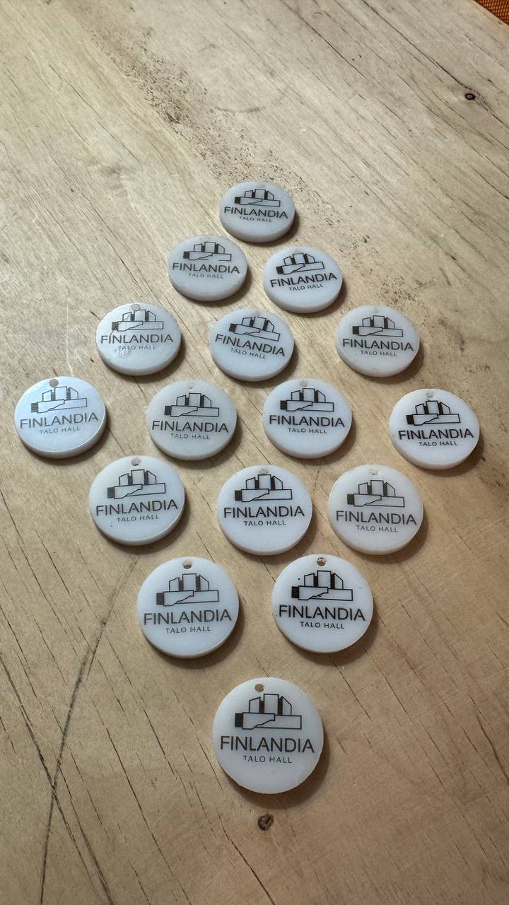 Valmiit opaalivalkoiset akryylitunnukset, joissa on Finlandia Talo Hallin logo.