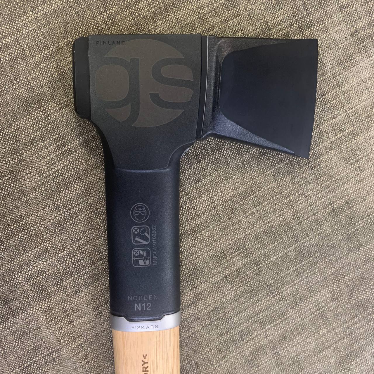 Laserkaiverrus Fiskars Kirveeseen Greenstepille – Tarkkuutta ja Brändiä 1 Lähikuva Fiskars Norden N12 kirveestä, jossa on laserkaiverrettu Greenstepin 'GS'-logo. Täydellinen laserkaiverrus Fiskars kirveeseen.